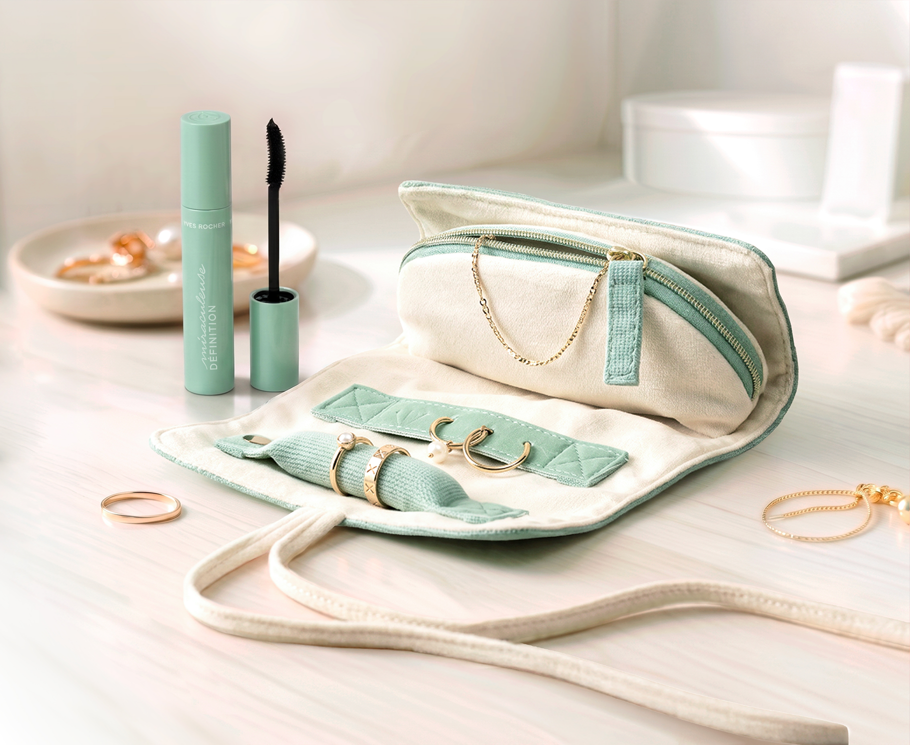 Trousse bijoux roulée verte ouverte avec mascara Yves Rocher et eucalyptus, sur plan de salle de bain
